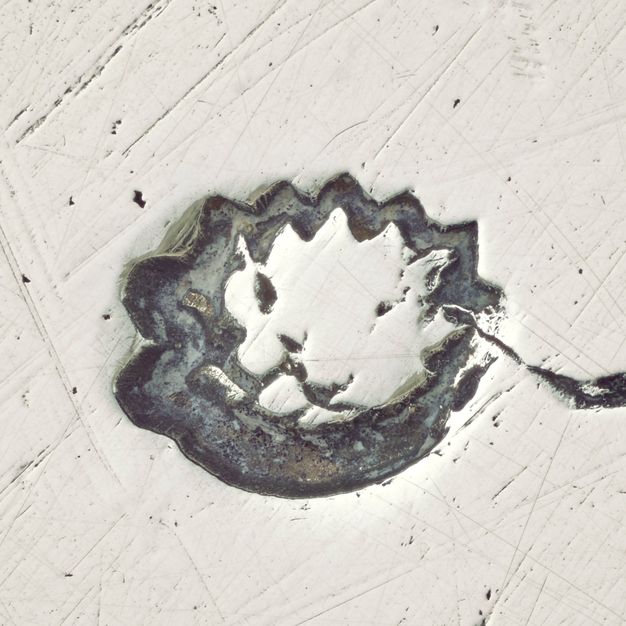 Close-up of an artichoke stamped on the stand.