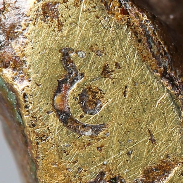 Close-up of a crowned C stamped on the gold-colored base.