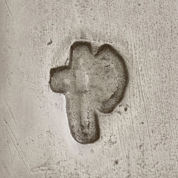 Close-up of an ax stamped on the vessel.