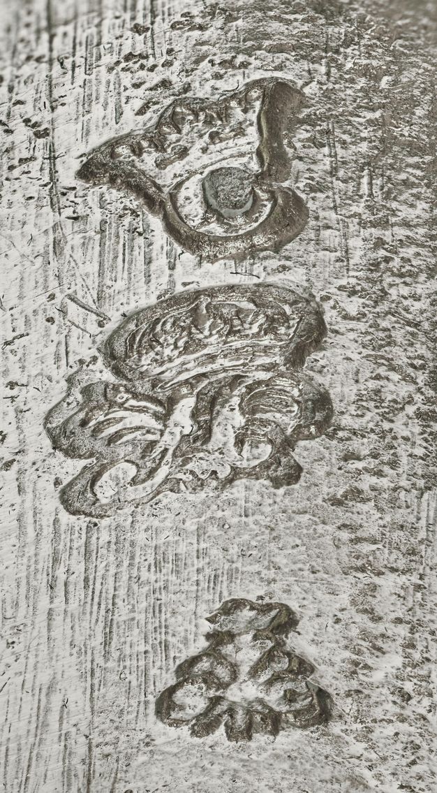 Close-up of a crowned C, crowned A, and the letters S and G stamped on the vessel.