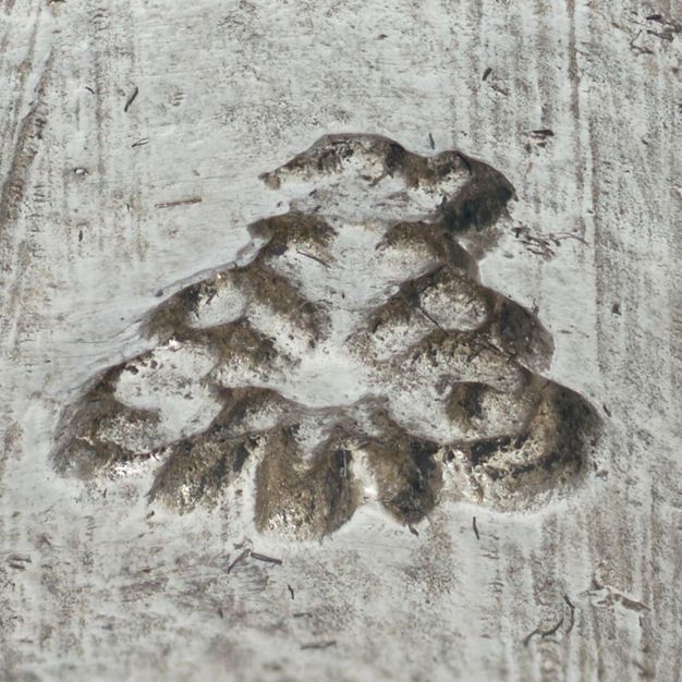 Close-up of the letters S and G surrounded by loops stamped on the vessel.