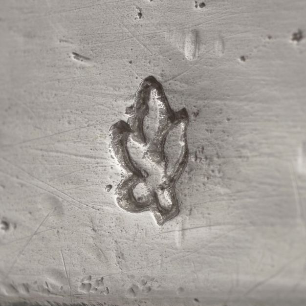 Close-up of four leaves on a stem stamped on the vessel.