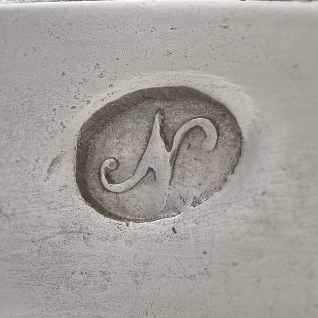 Close-up of a N with flourishes in an oval stamped on the vessel.