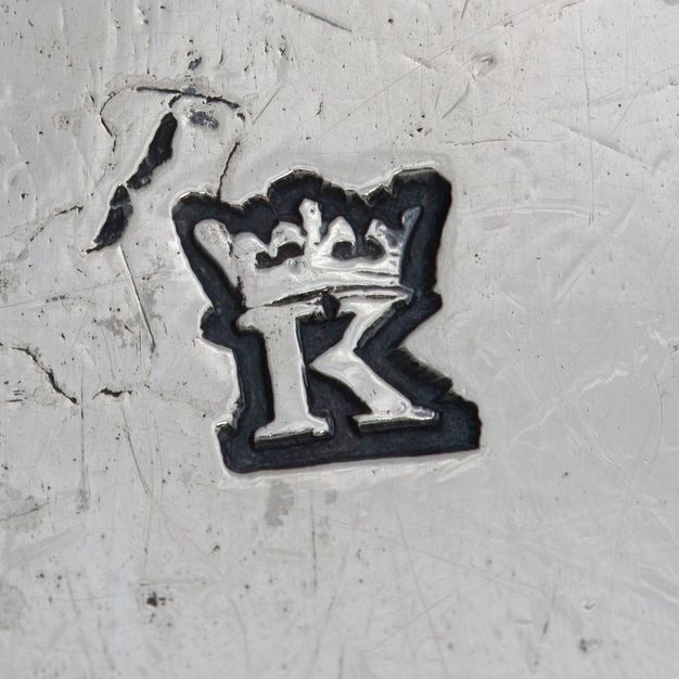 Close-up of a crowned K stamped on the stand.
