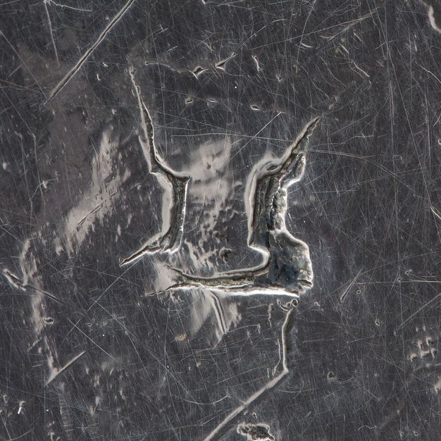 Close-up of a crowned I stamped on the stand.