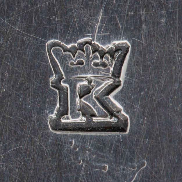 Close-up of a crowned K stamped on the stand.