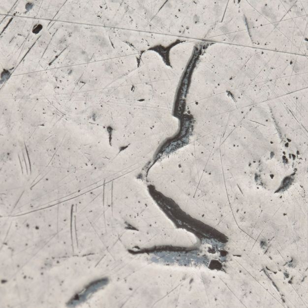 Close-up of a crowned K partially stamped on the tray.