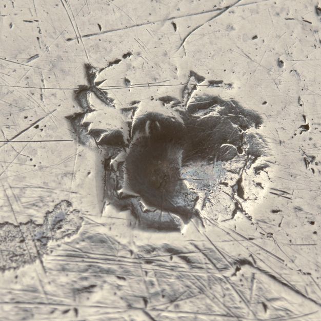 Close-up of a crowned A with laurel branches stamped on the tray.