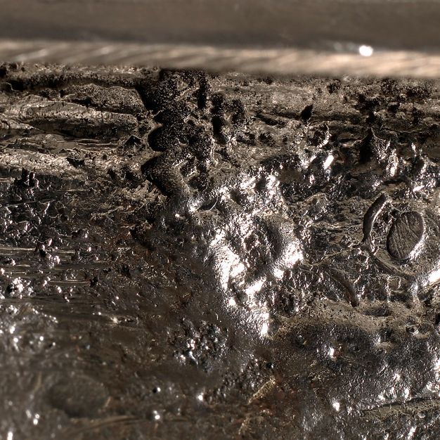 Close-up of the letters FTP and a crowned O partially stamped on the centerpiece.