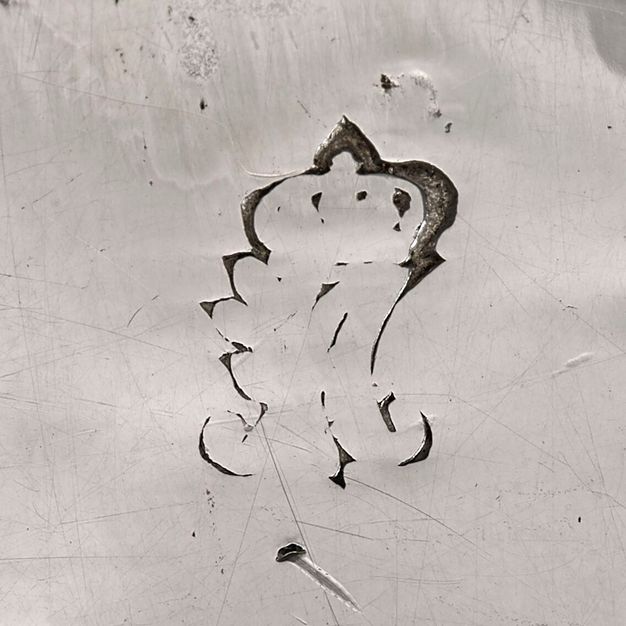 Close-up of a faded crowned A stamped on the sauceboat.