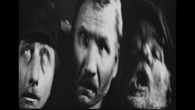 The first of three black-and-white still frames shows three men’s elongated, blurry faces grouped together facing the viewer, looking stunned with mouths agape.