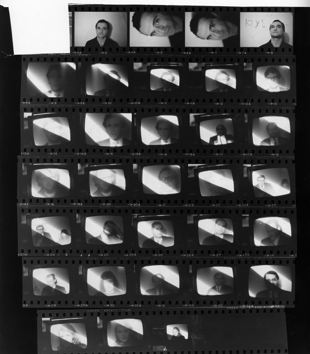 An image of black-and-white film negatives showing a variety of individuals, one face per frame, from the shoulders up against a white background within a television screen. Most of the figures are men and many are wearing suits.