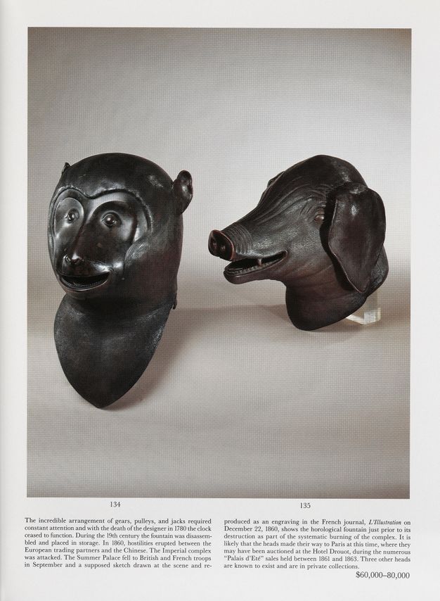 A page from an auction catalog featuring a large photograph of two bronze animal heads, a monkey and a boar, both in three-quarter profile. Two columns of descriptive text appear under the photograph.