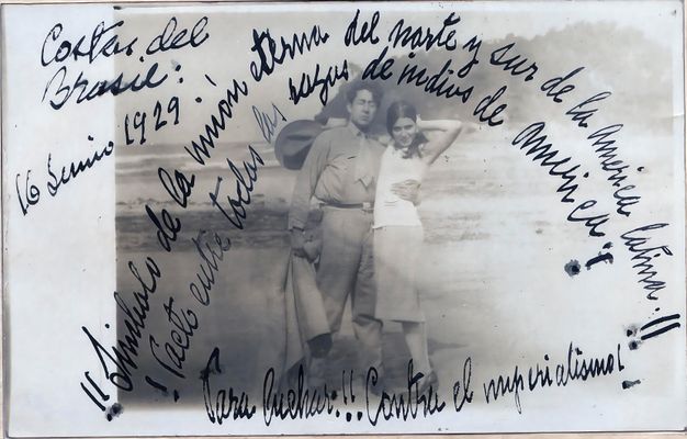 Black-and-white photograph depicting a man and a woman embracing in a side hug on a beach, looking toward the camera. Words, handwritten in ink, form an arch around the two figures.