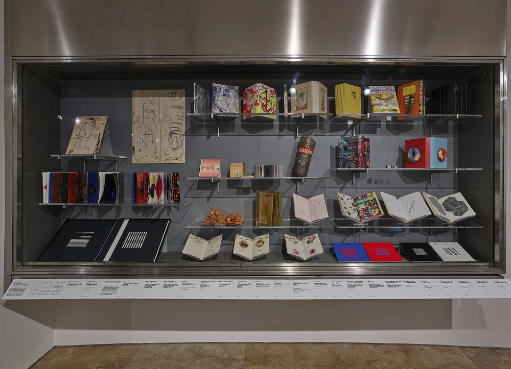 A glass case showcasing several medium-size and large size book sculptures