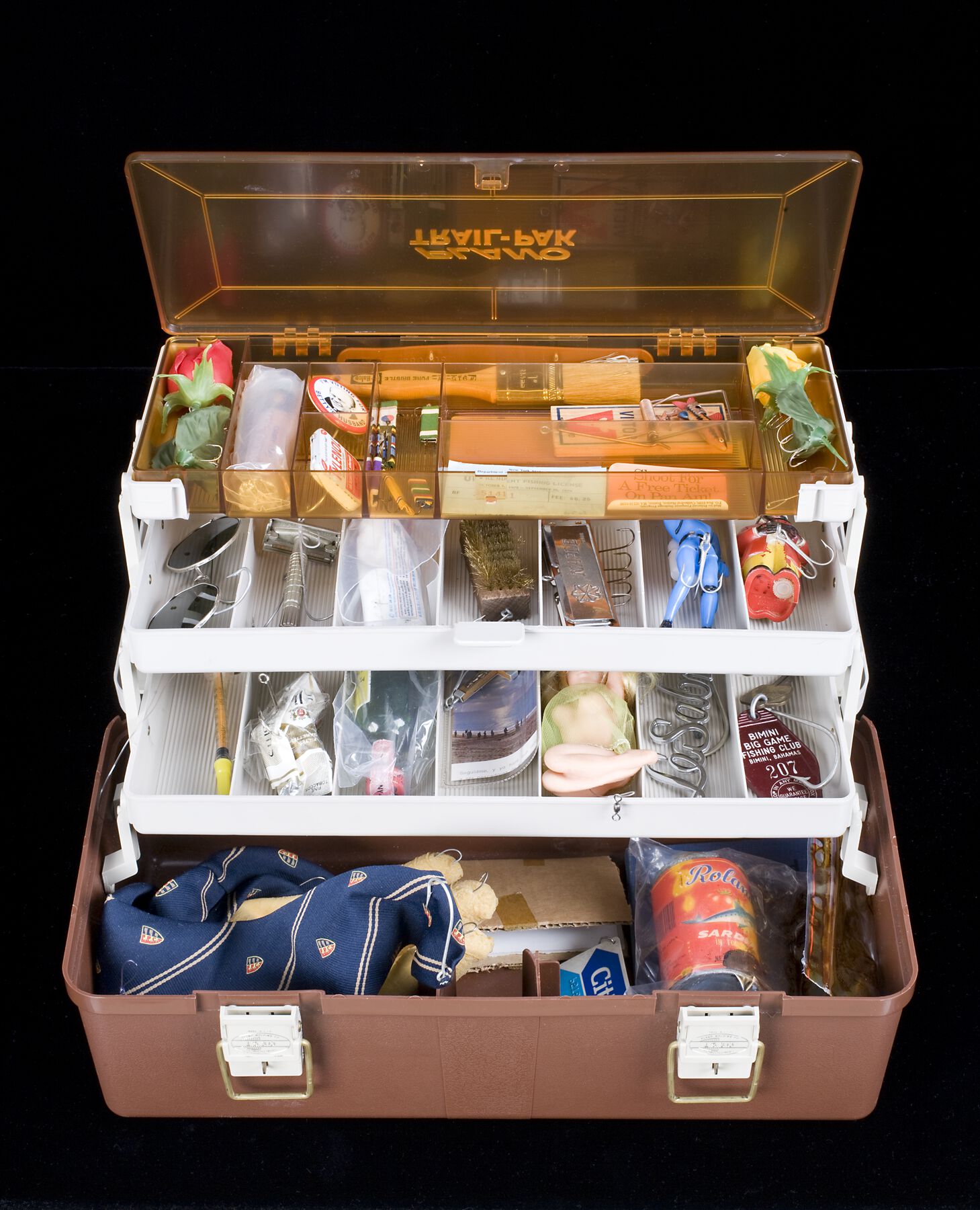 An orange, three-layer tackle box with trinkets and objects taking up every space