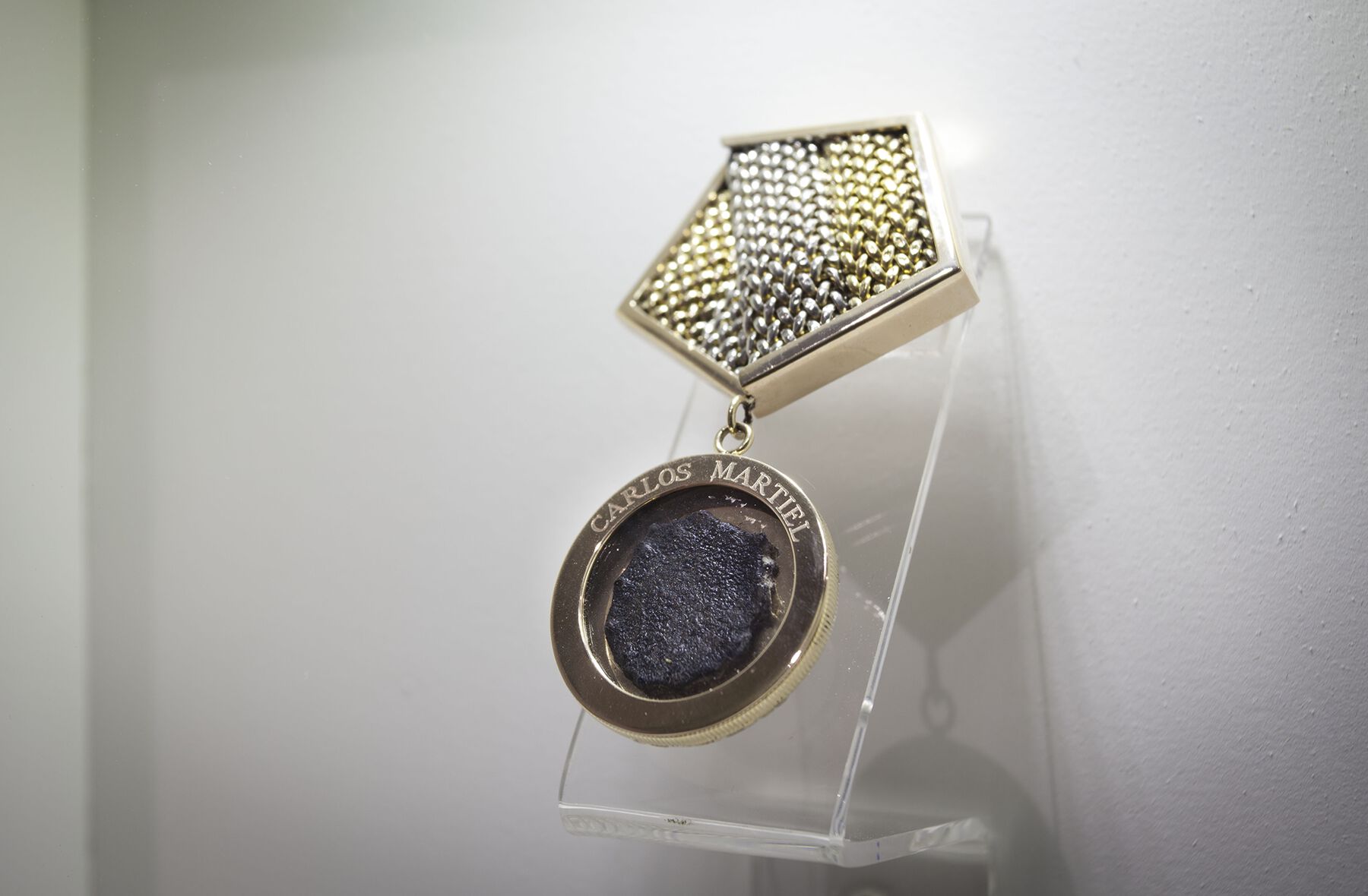 The blackened dried-up skin placed in a golden medal with the artist's name inscribed on it