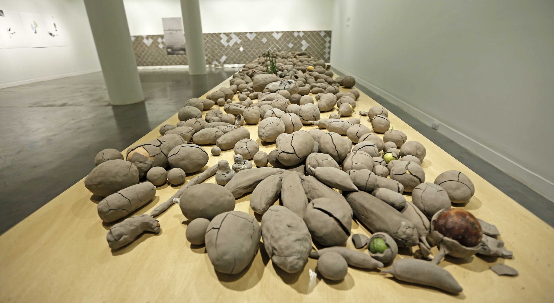 A close-up of the encased clay vegetables and fruits some of which are cracked