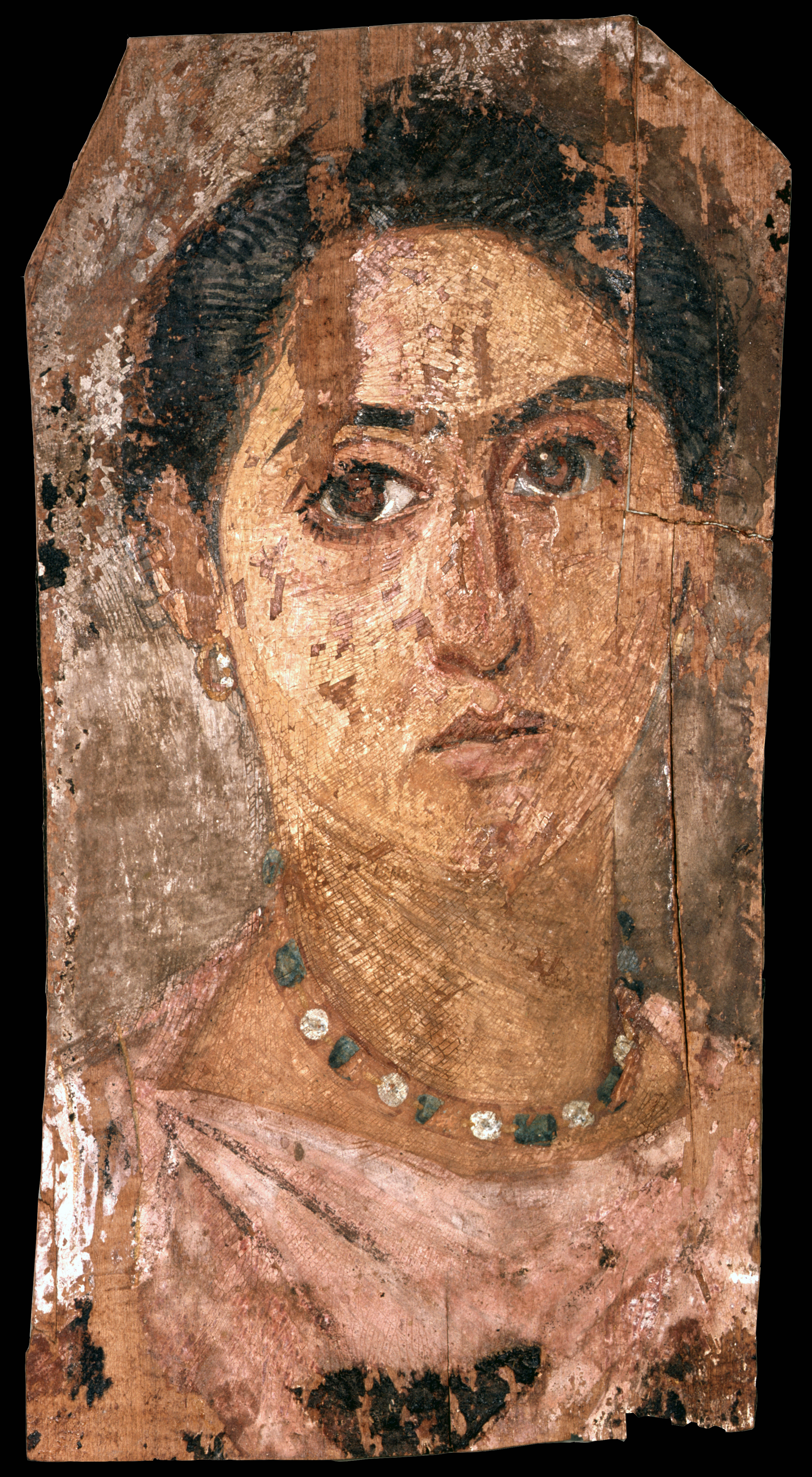 Portrait of a woman with dark brown hair and brown eyes. Her hair sits on top of her head, and she is shown wearing a pink tunic, gold earrings, and a green and white necklace.