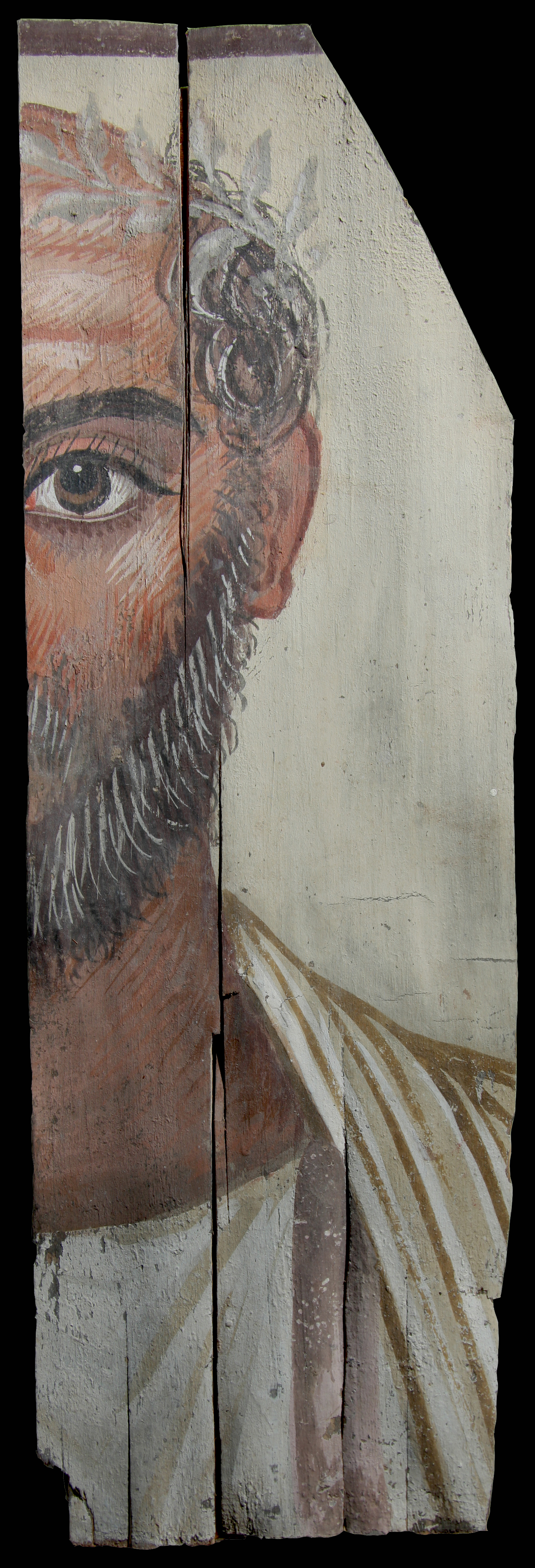 Partial portrait of an old man. Only half of the man’s face and upper body is shown. His brown right eye is visible. He has grey hair and facial hair. On his head, he is wearing a wreath with white leaves that wraps towards his forehead. His garments are white in color, and his skin is tan. There is white detailing on his skin to show aging.