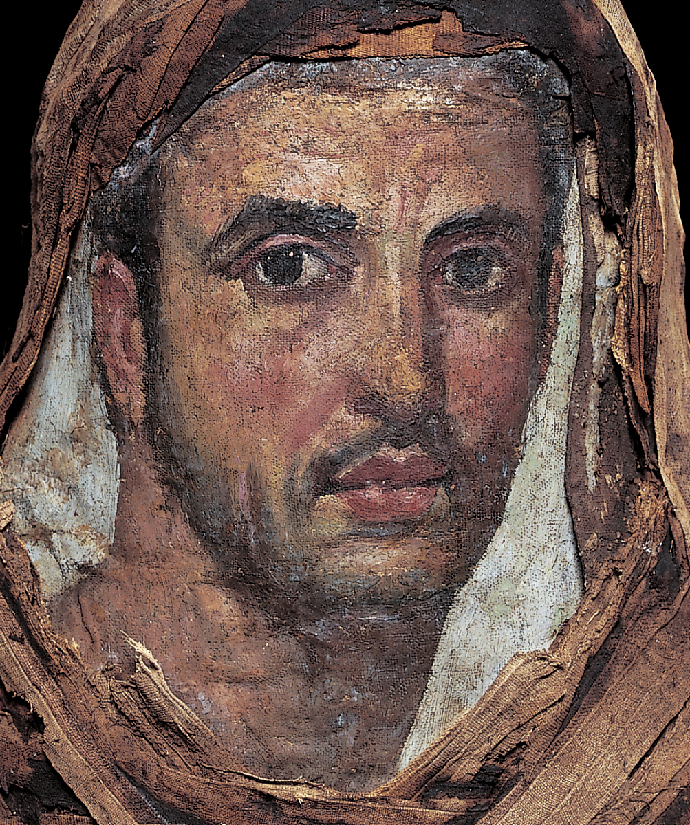 Portrait of a man attached to a mummified individual as indicated by the linen wrappings that can be seen around the painting and partially covering the man's short hair as well as the area below his neck. He has dark hair, eyes, and eyebrows as well as a stubbly beard and a thin moustache.