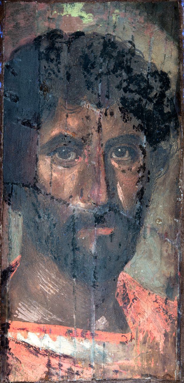 UV fluorescence photograph of the man's portrait. The red in the tunic is brighter and there is white along the collarbone. The hair and skin have darkened and the upper right corner of the portrait is black and stands out.