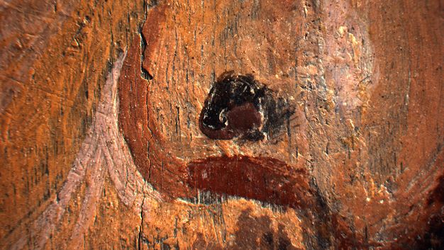 A close-up image of the mole on the man's nose in a portrait. There are three distinct colors used: black, brown shading around the left side of the mole showing the contour of the nose, and a highlight on the right side.