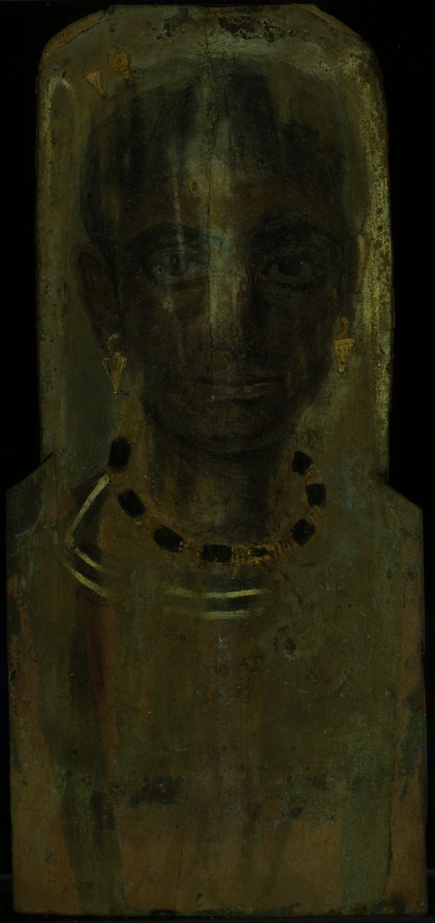 Image of a portrait under ultraviolet-induced visible fluorescence. The image appears very dark and the facial features of the invidual are difficult to make out. A yellow-greenish fluorescence can be seen around the head, down the nose, and around the collar.