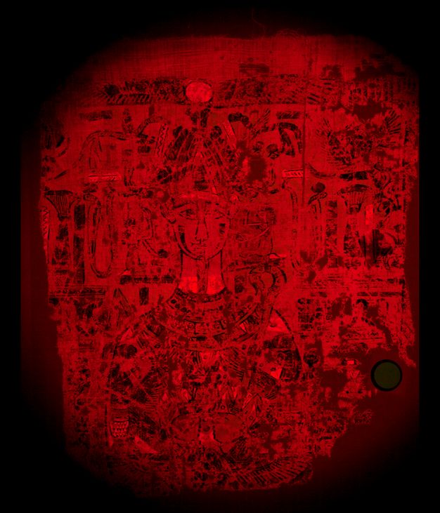 Image of the upper part of the Osiris shroud under visible-induced visible luminescence. The entire image has been washed with a red tint. The outline of the decorative motifs on the shroud appear as black.