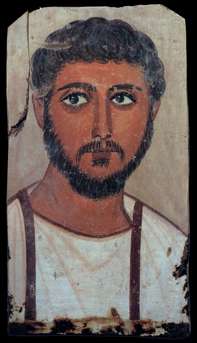 Portrait of a man with brown hair, eyes, and facial hair. His skin appears tan in color, and he is wearing a white shirt with brown detailing. 