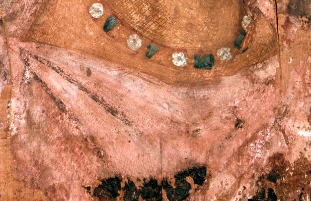 Close-up visible image of the tunic in figure 5.2. The tunic is a light pink with shading in the folds around the proper right shoulder. There is a dark stain beneath the collar. 