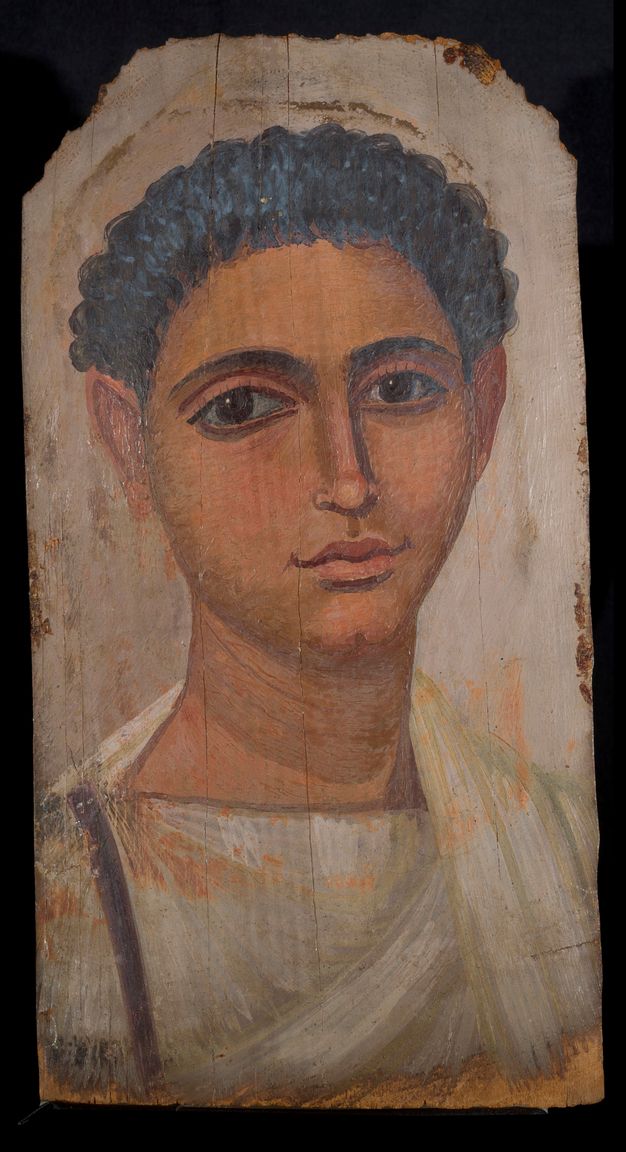 Portrait of a man with dark short hair, brown eyes, and fair skin. He is wearing a white garment with brown ribbon-like vertical detailing on his left side. The background is tan in color. 