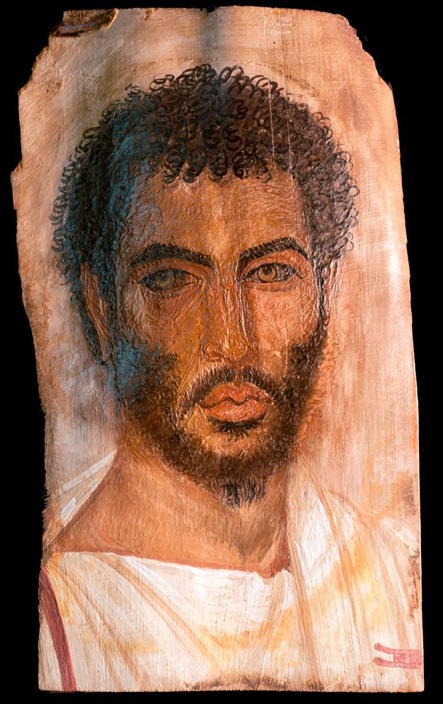 Portrait of a bearded man wearing a white tunic. His hair is textured to show tight curls.