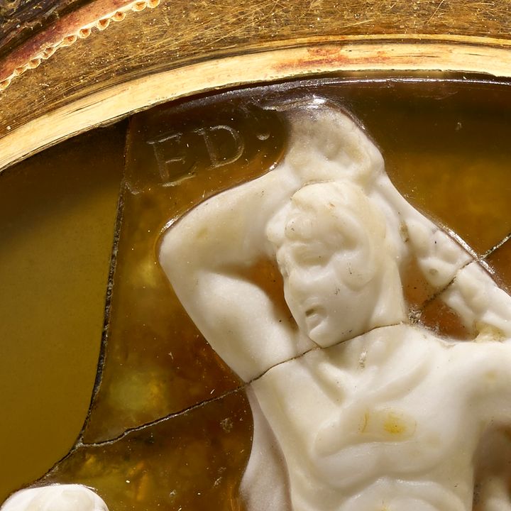 'Detail of the cameo shown in Figure 12a. Incised in the yellow stone above the main figure''s forearm are the letters E and D. The section to the immediate left of the inscription is missing but a small segment of an additional letter can be seen.'