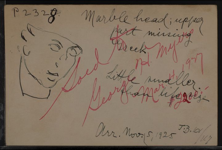 Piece of paper with a sketch of the head shown in Figure 30 to the left and overlapping handwritten, cursive notes in red and black ink filling the rest of the sheet. Black writing to the right reads quote Marble head; upper part missing, Greek. Little smaller than life size. Arrival November 5, 1925 end quote. Red text written across the black reads quote Sold to George H. Myers, March 4, 1927, 2200 dollars end quote.