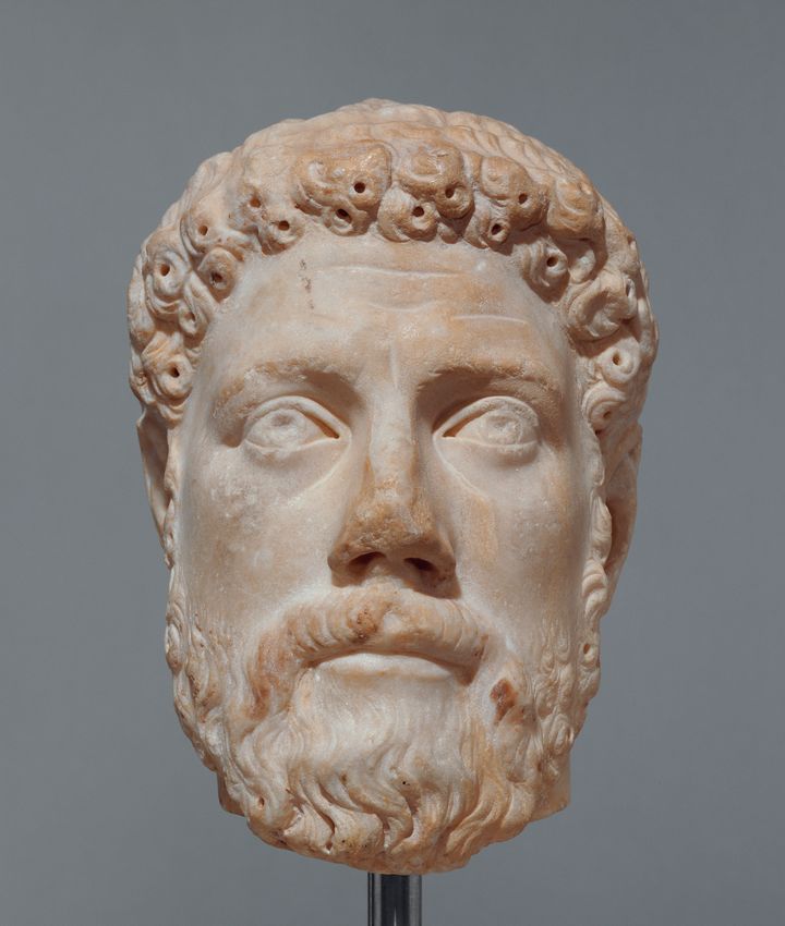The isolated head of a man looking slightly up, with short, curly hair, and a full beard on a square jaw. This sculptural head is the same as that shown in the center of Figure 37 but no longer features the chest.