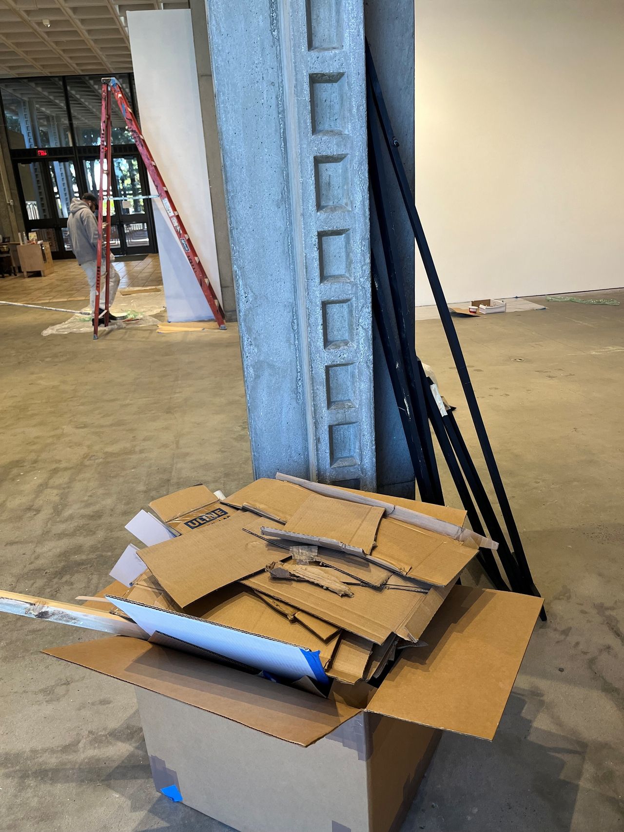 A cardboard box full of deconstructed cardboard in a gallery setting.