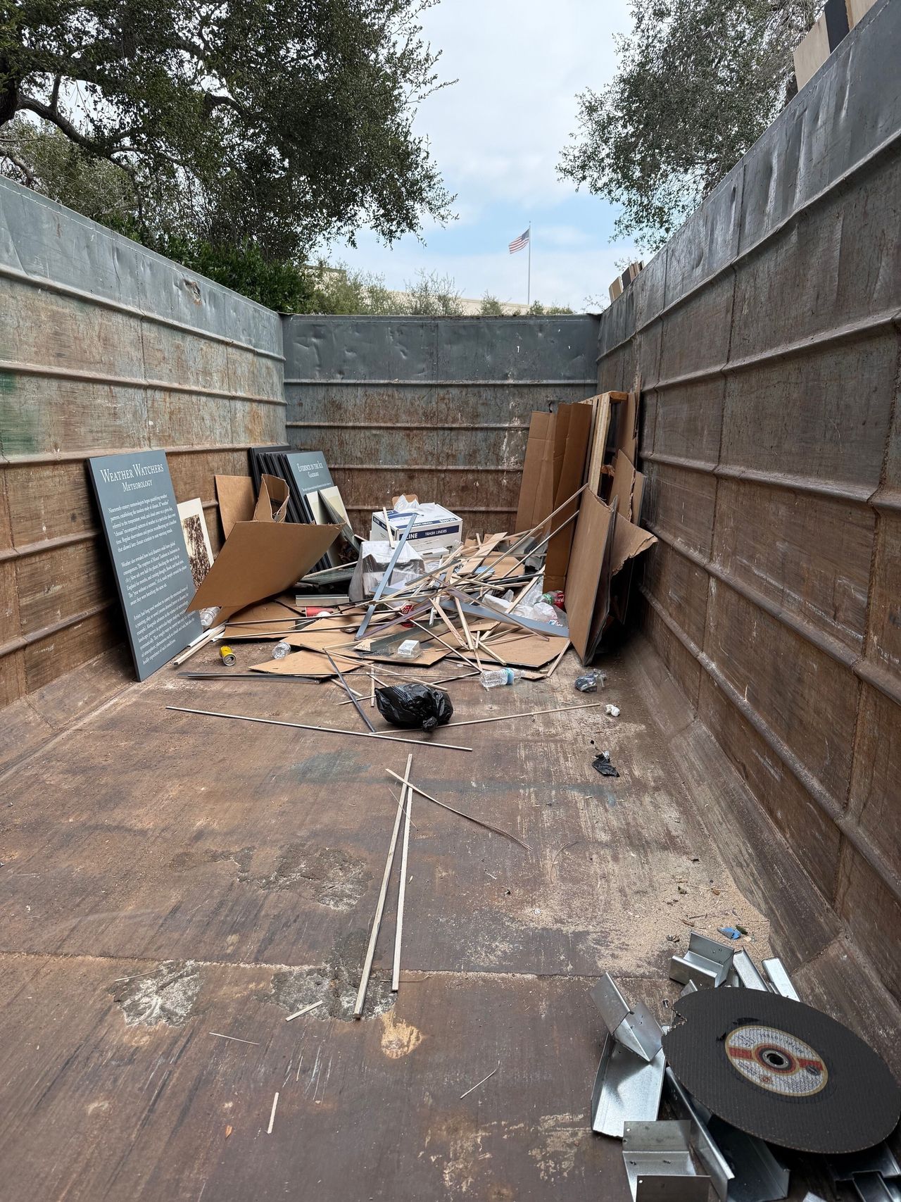 Large, brown crate space with no top containing remnants from an exhibition.