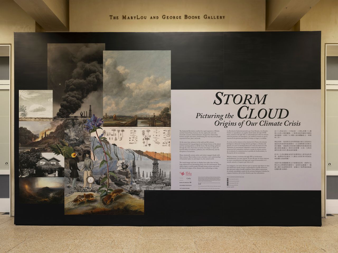 Large black wall that has a white rectangle that says quote Storm Cloud: Picturing the Origins of Our Climate Crisis end quote along with a description of the show next to examples of paintings of storm clouds.
