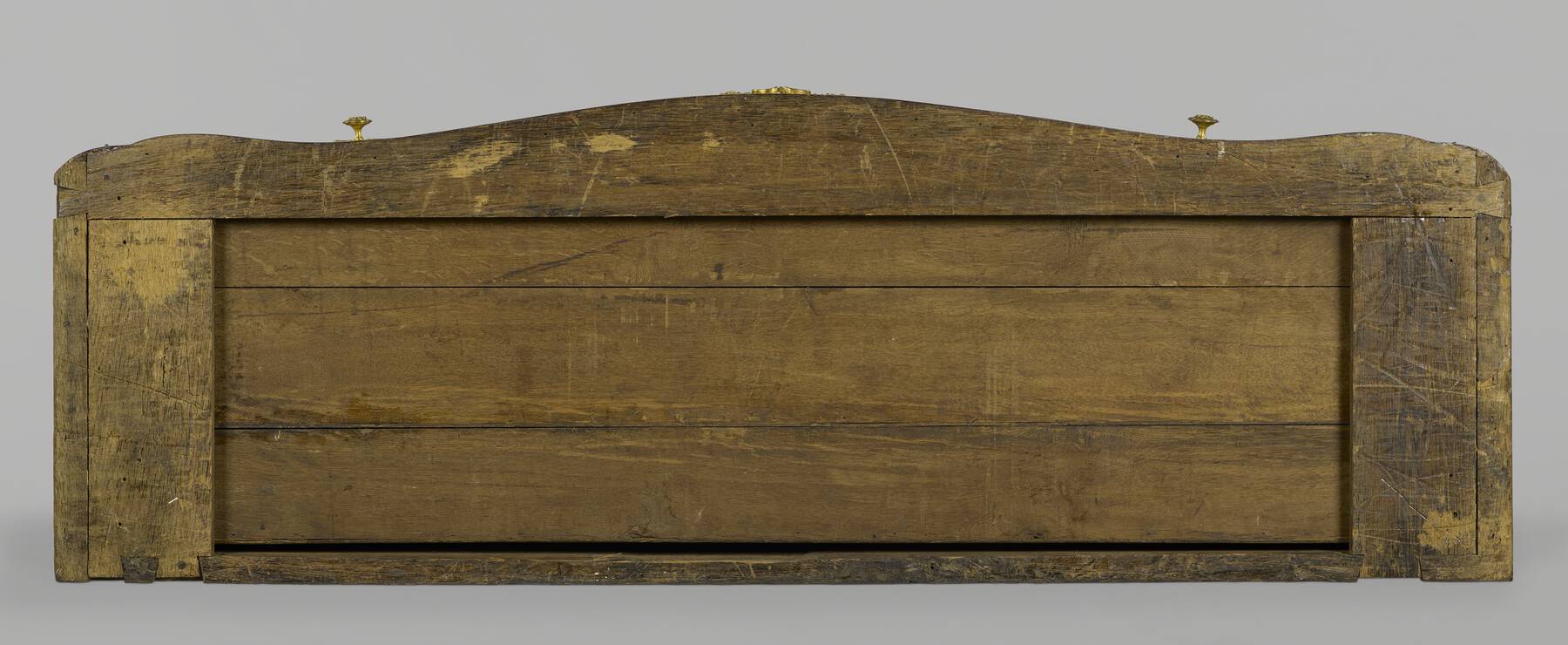 the bottom of the cabinet from below, showing three long horizontal panels within a framework of structural wood pieces