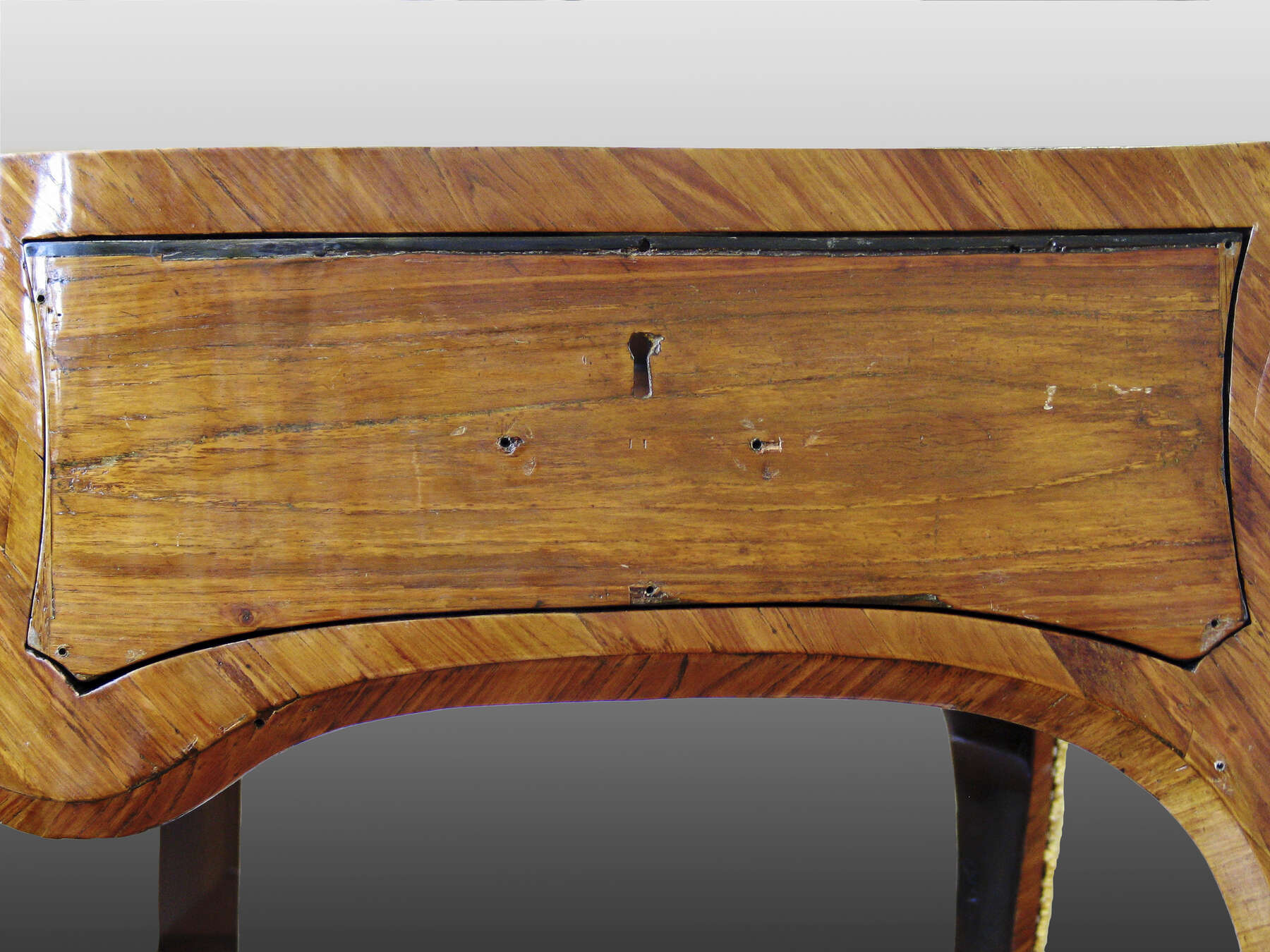 the replacement veneer on one of the drawers —without the mount— has a soft, horizontal grain structure that is noticeably different from the original veneer