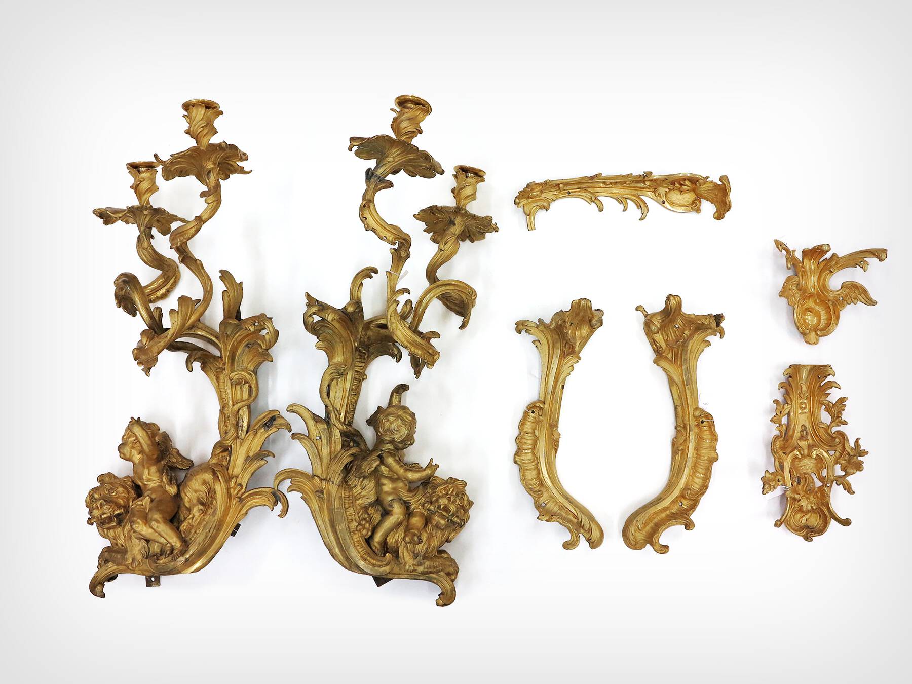 seven gilt bronze mounts with foliate designs and cherubs as seen when removed from the cabinet