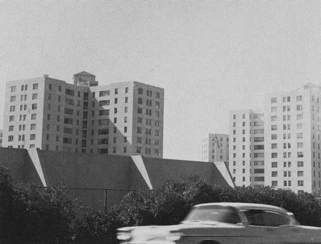 A page from a book showing a small black-and-white photo placed at top right, featuring a building shot from a distance.