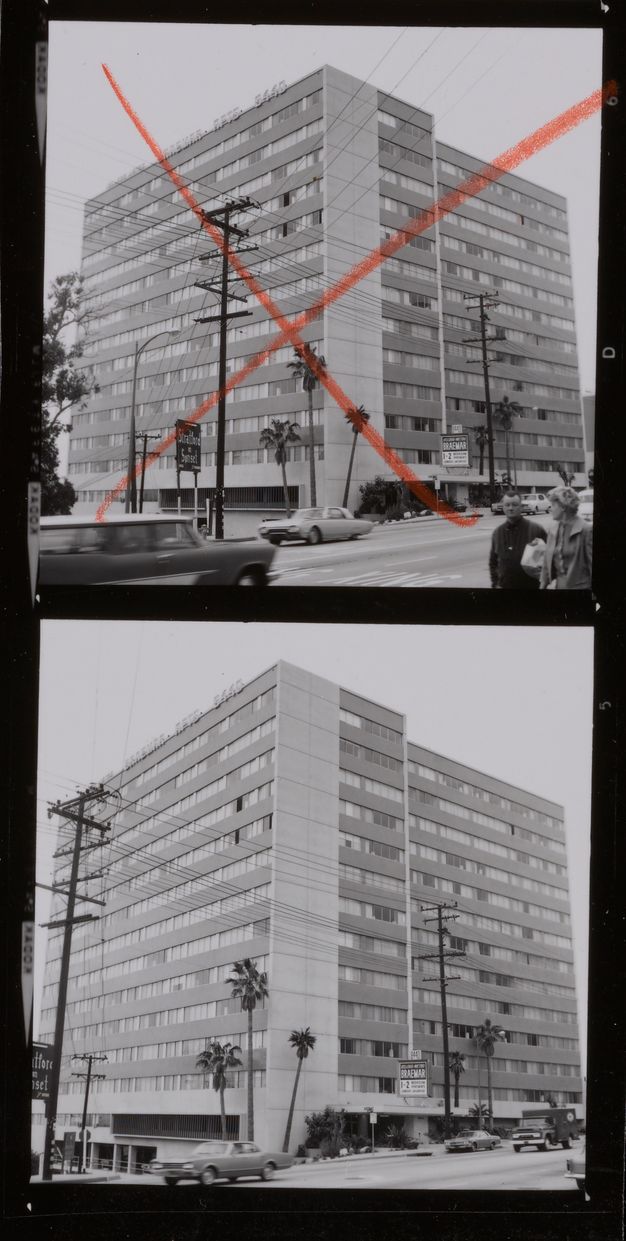 A contact sheet showing two black-and-white photos of the same multi-story apartment building. A red “X” is drawn over the top building.