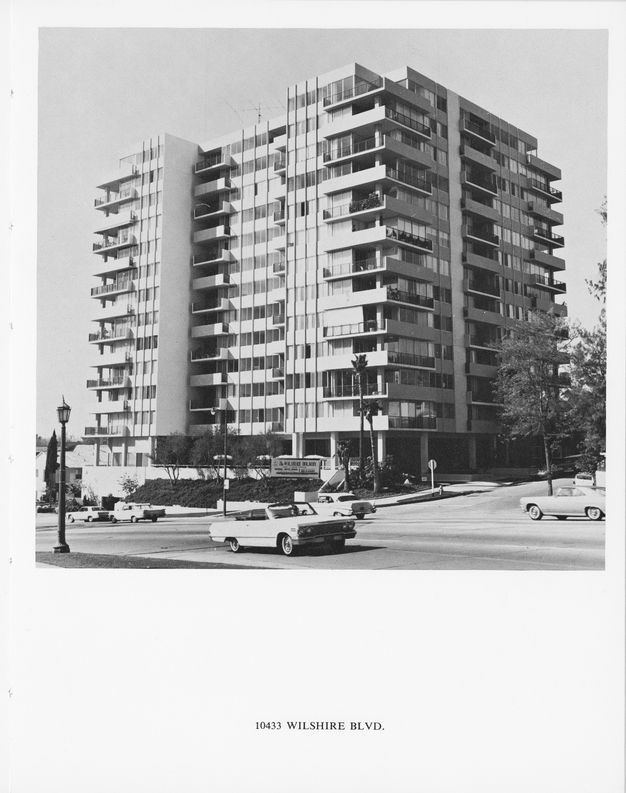 A page from a book showing a black-and-white photo of a multi-story apartment building shot at an oblique angle. A caption below the photo reads “10433 Wilshire Boulevard.”