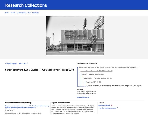 A screenshot of a website with a black-and-white photo of a building on a street corner. Archival collection information appears below the photo.