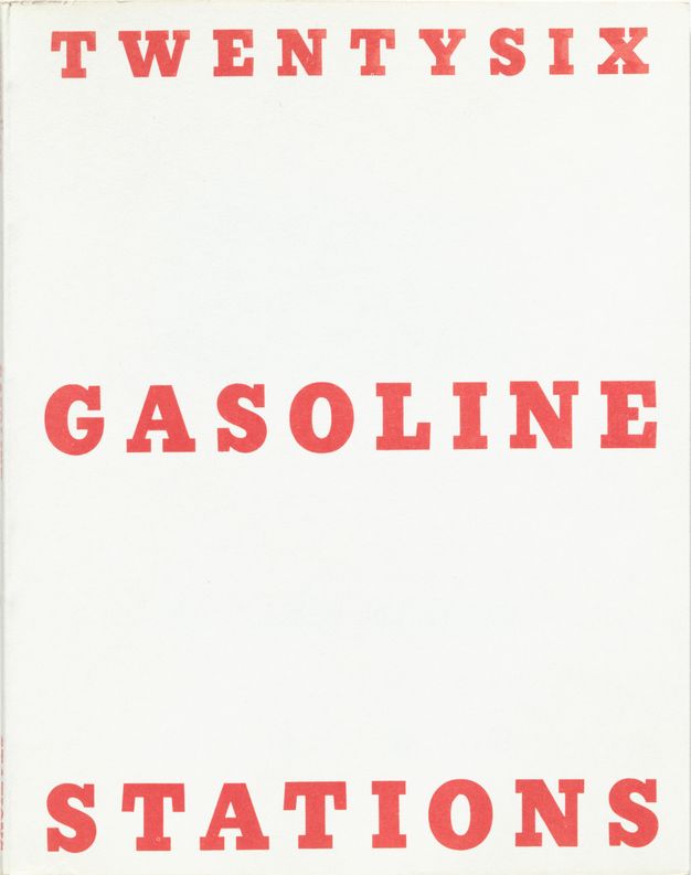 A white book cover features the title “Twentysix Gasoline Stations” in all caps, red script. Each of the three words occupies its own line, spaced evenly from top to bottom of the white cover.