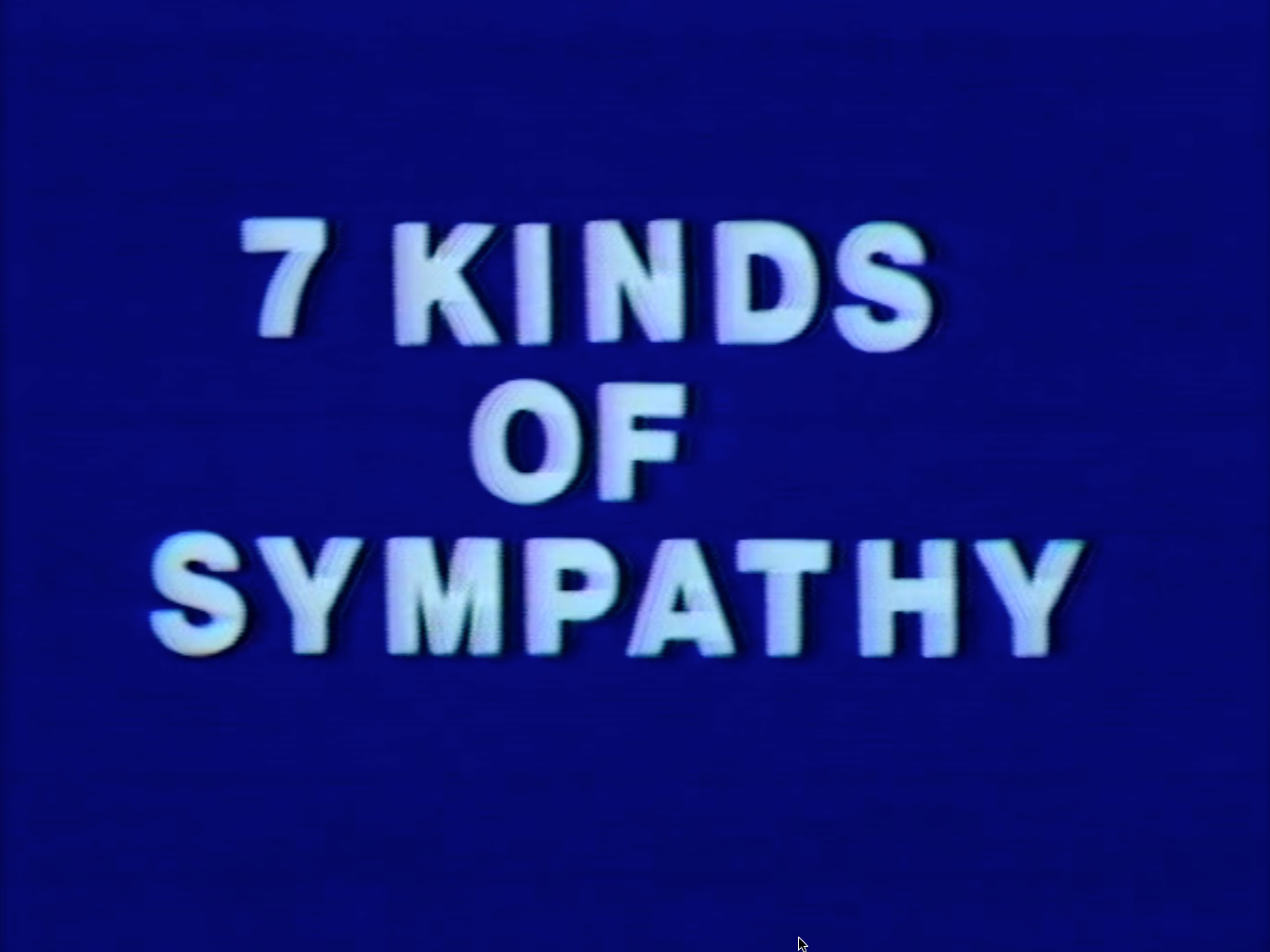 Color film opening with male voiceover and blank white screen followed by title card “7 Kinds of Sympathy” in white on blue background. Film cycles through 1) a male voiceover accompanied by blank white background, 2) a color video of one or two people, either together or separate, performing actions from the voiceover, and 3) a title card with “later...” in white on blue background. Shots are stable and either close-ups focusing on hands or faces or wide shots of chest-up/full-body figures. Close-ups often capture movement or speech. Figures or hands are typically at the center of the frame, with no other points of visual interest. Background of scenes is either solid orange or solid red. Both figures wear maroon plain clothes. Four by three aspect ratio.