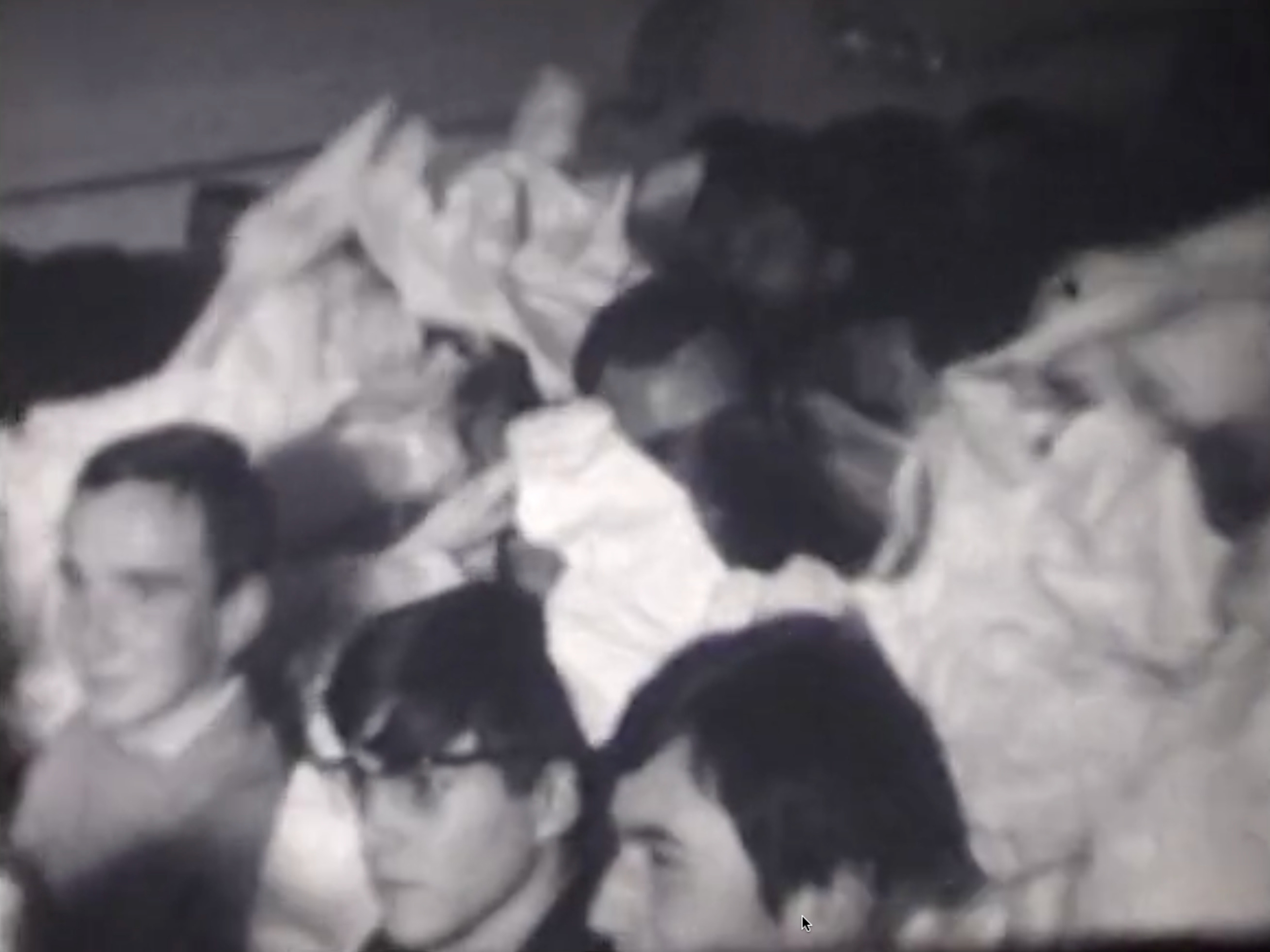 Black-and-white film depicting audience members in a large hall receiving, tearing, passing, and throwing masses of large and small scraps of paper, as well as empty egg cartons, that have been tossed out to them from figures on a stage. Voiceover by Ben Vautier (added at a later date) describes the performance and audience members’ joyful reactions.