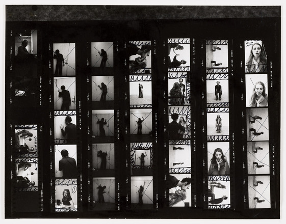 Contact sheet with seven rows with five black and white photographs each. Photographs show back of shadowed figure leaning on a white door, one woman and one man pressing hands together, and one or two figures sitting in chairs. Some images marked with black marker to indicate square-shaped cropped frame. Others crossed out with X. 